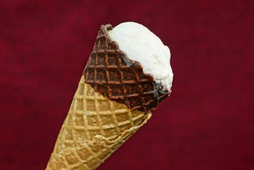 one white ice cream in a brown waffle cup on a red background