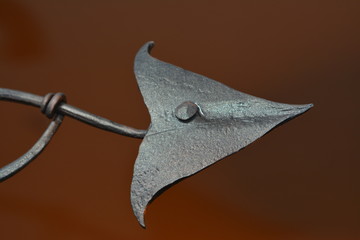 Iron forged arrowhead on a brown background