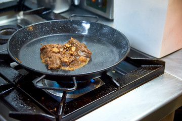 Solid broth sofrito for paella foundation preparation. Heating in a pan.