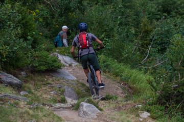 Obraz premium Cyclist in Red Riding the Bike on the Autumn Rocky Trail at Sunset. Extreme Sport and Enduro Biking Concept