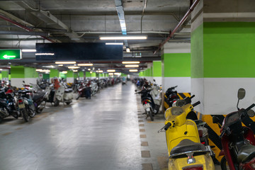 Motorcycles and scooters park in the underground basement parking of the apartment