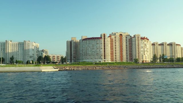 Panorama of the embankment of the Neva River at sunset. View from the ship. The passenger person looks at the old and modern architecture from a cruise ship.