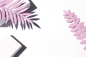Tropical leaves shadows on the white paper background on the noon sun. Summer concept frame. Copy space