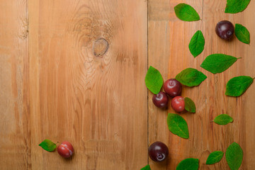 Ripe juicy plums on wooden table. Top view.