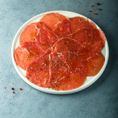 Homemade beef carpaccio with salt and pepper