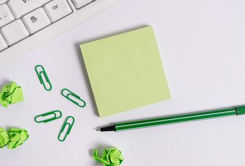 Square empty green note paper with pencil on the white background and pc keyboard.