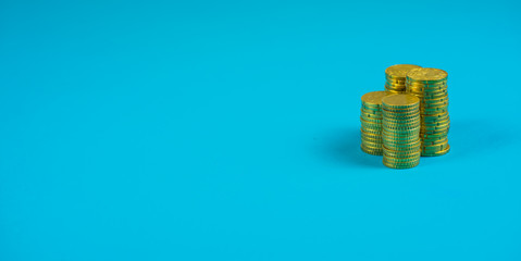 stack of coins on blue background with space for designer