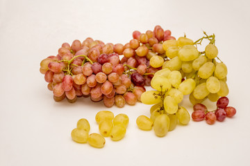Red and white grapes on neutral background