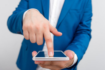 Businessman in the blue suite with lap top pointing with finger.
