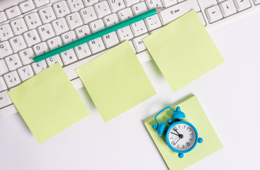 Three empty green square papers pencil clock by the pc keyboard with copy space.