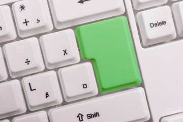 White pc keyboard with empty note paper above white background key copy space