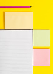 Colored empty papers with copy space on the yellow background table.