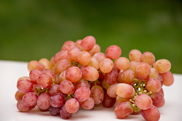 Red grapes on green and white background