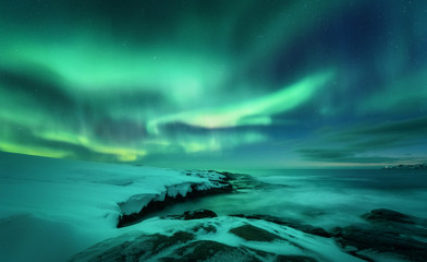 Aurora borealis over ocean. Northern lights in Teriberka, Russia. Starry sky with polar lights and...