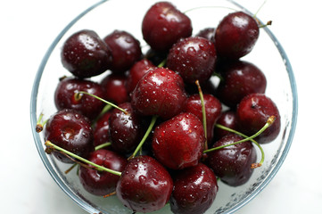 Wet fresh red cherries in a glass bowl