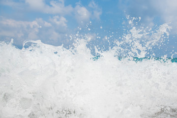 sea wave crashing on shore with spray of water