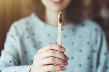 woman holding eco-friendly bamboo toothbrush, zero waste way of life, dental care