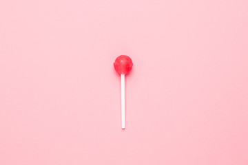 Sweet pink candy lolipop on pastel pink background.Minimalist composition.