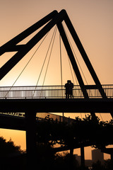 Obraz premium Düsseldorf 2019: Silhouette of two male persons standing close to each other on a brigde over the rhine in sunset