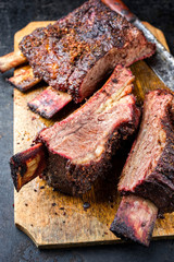 Barbecue sliced chuck beef ribs with hot rub as closeup  on a wooden cutting board