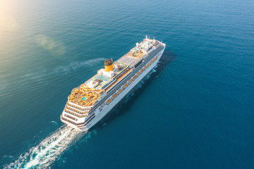 Cruise ship liner sails in the blue sea leaving a plume on the surface of the water seascape....