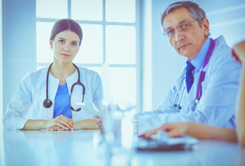 Serious medical team analysing a patient's disease in a bright hospital room