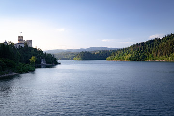 Obraz premium The setting sun on the lake, the Niedzica Castle / landscape