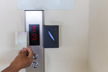 securing lift or elevator access control. elevator access control, Hand holding a key card to...