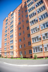 Fototapeta na wymiar Modern and new apartment building. Multistoried, modern, new and stylish living block of flats. Real estate. New house. Newly built block of flats