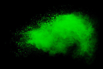 Green powder explosion on black background. Colored cloud. Color dust explode. Paint Holi.