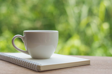 Coffee espresso on wood table nature background in garden,warm tone