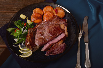 Grilled beef steak and grilled apricots with salad on a platter