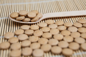 Alternative medicine tablets on a wooden spoon