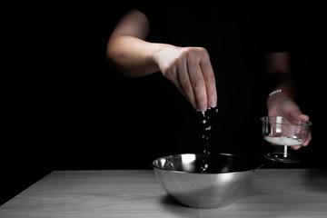 Woman chef sprinkles salt and seasoning for marinated fillet by condiment on a wooden table in the kitchen . Hand sprinkles salt for Preparing healthy food Cooking menu at Home .