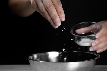 Woman chef sprinkles salt and seasoning for marinated fillet by condiment on a wooden table in the kitchen . Hand sprinkles salt for Preparing healthy food Cooking menu at Home .