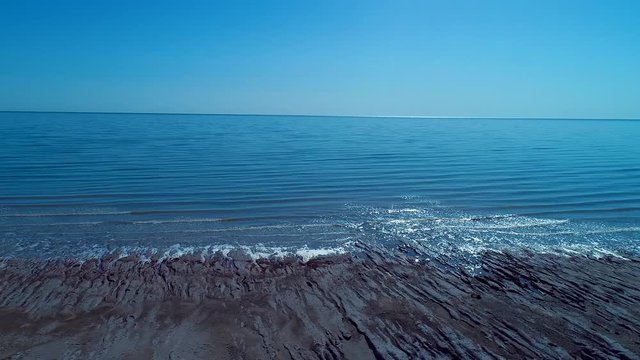 Sea foam at the beach of the Aral Sea near Aktumsuk cape at sunset in Karakalpakstan, Uzbekistan.