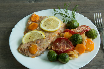 Baked white fish with lemon, cabbage, carrots, tomatoes, potatoes