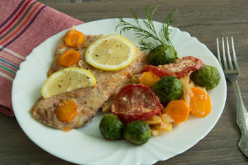 Baked white fish with lemon, cabbage, carrots, tomatoes, potatoes
