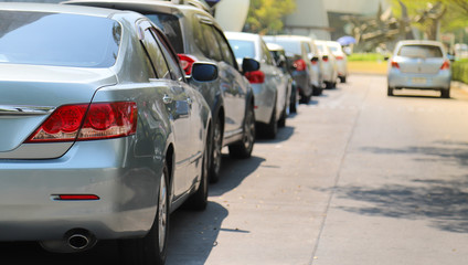 Closeup of rear or back side of green blue car with other cars parking in outdoor parking area...