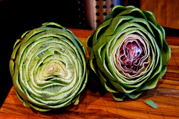 Two Trimmed artichokes on cutting board ready for steaming 