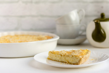 Royal cheesecake, delicious fresh cottage cheese cake with shortbread cookies and tea utensils on the table