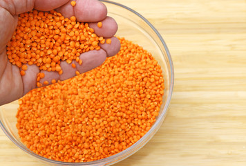 hand letting lentils trickle into a bowl