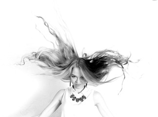 black and white joyful woman with flying hair on light background