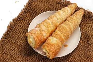 two pastry horn with white cream filling and sack. creamy cones. creme horns isolated on white background