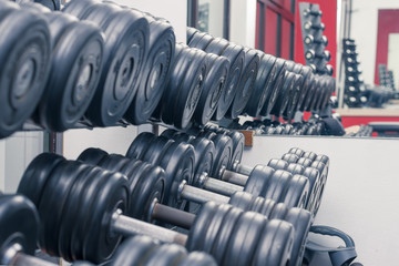 Naklejka na ściany i meble Dumbbells in the gym, the concept of sports, healthy lifestyle. Close up..
