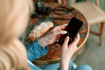 Woman with mobile enjoying the day in cafe outdoors
