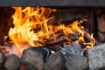 Obraz premium Close-up of the fire of a barbecue with burned firewood and ashes.