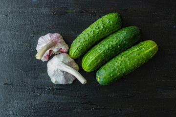 Cucumbers and garlic on a black background.