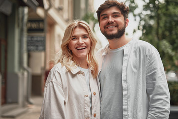 Happy couple standing near the building and smiling