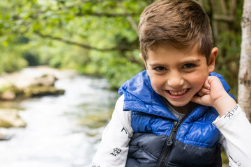 Beautiful boy smiling near of a river